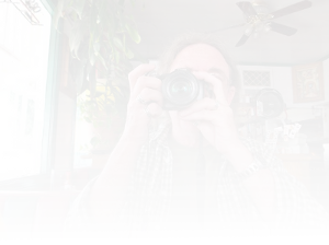 background picture of the author with a camera